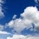 A serene blue sky adorned with fluffy white clouds.