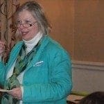 Dec2011JanFeb2012 156 A mum in a green jacket speaking to a group of people about work-life balance for women returners.
