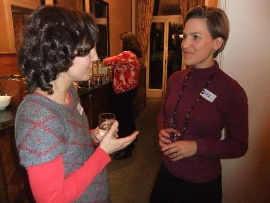 Two working women discussing their work-life balance at an event.