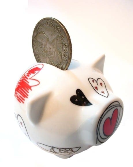 A piggy bank with a coin and hearts on it, symbolizing financial stability and love.