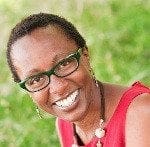 A smiling woman wearing glasses and a red top confidently embodies work-life balance.