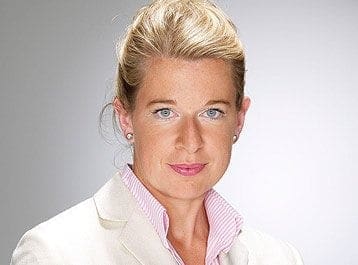 A woman in a white blazer and pink shirt, exemplifying career professionalism with style and grace.