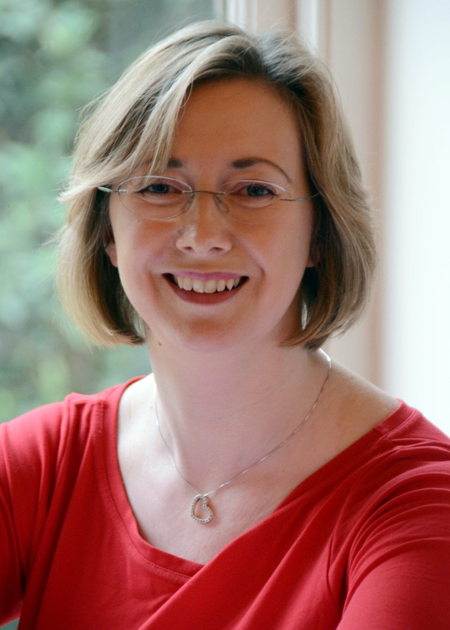 A career-oriented woman successfully achieving work-life balance while wearing a red shirt.