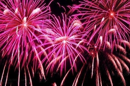A vibrant pink fireworks display illuminates the night sky, captivating spectators with its mesmerizing beauty.