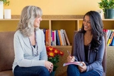 Two women returners sitting in a room discussing career opportunities.