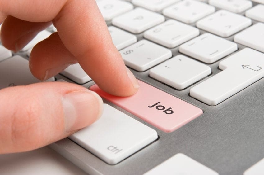 A woman pressing the job button on a keyboard.