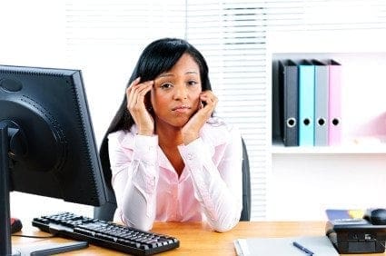 A woman at a desk, balancing work and life with a computer in front of her.