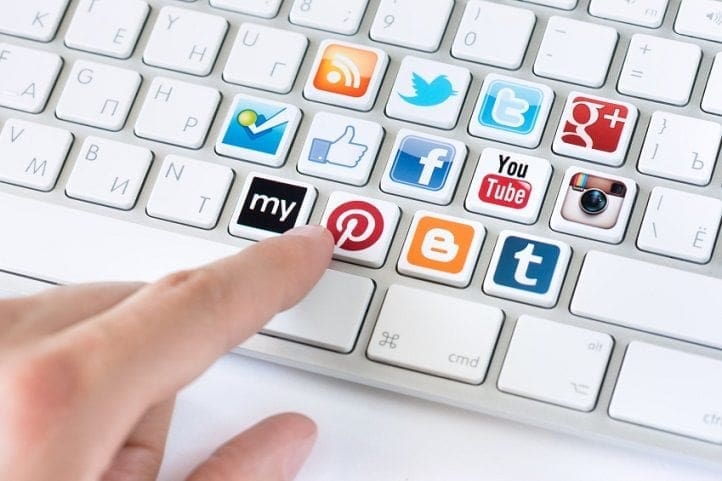 A person is working on their career by typing on a keyboard with social icons.
