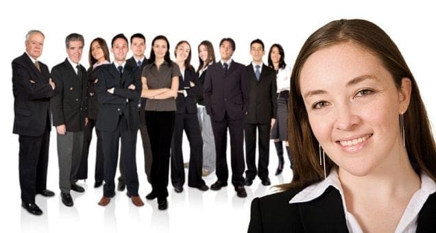 A working woman is standing in front of a group of business people.