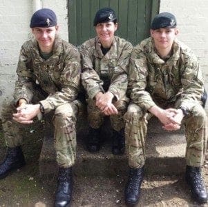 Three soldiers, maintaining work-life balance, in uniform posing for a photo.