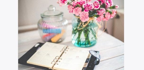 A working mum's notebook adorned with beautiful flowers and a vase on a table.