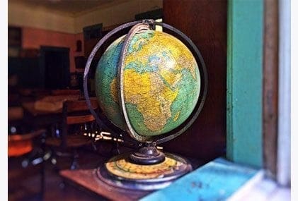 A career-oriented mum finding work-life balance with a globe sitting on a table in front of a window.