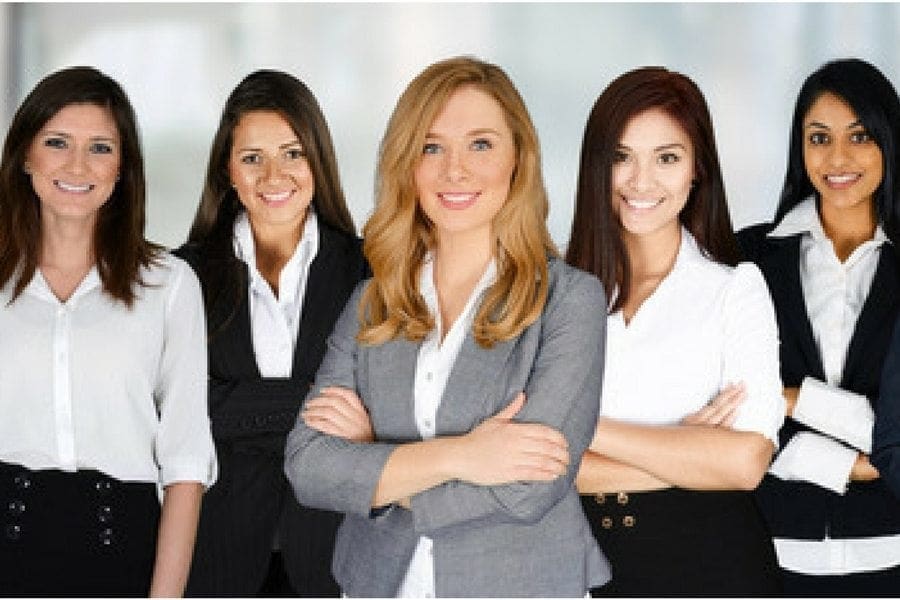 A group of working women posing for a photo at their jobs.