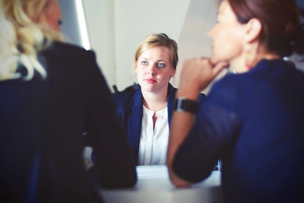Three women who are women returners sit at a table and engage in a conversation.