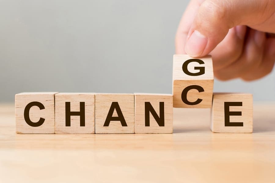 A person is holding wooden blocks that spell out the word mum.