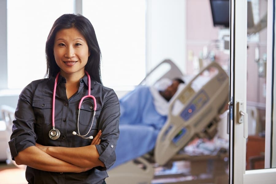 A nurse working diligently beside a hospital bed.