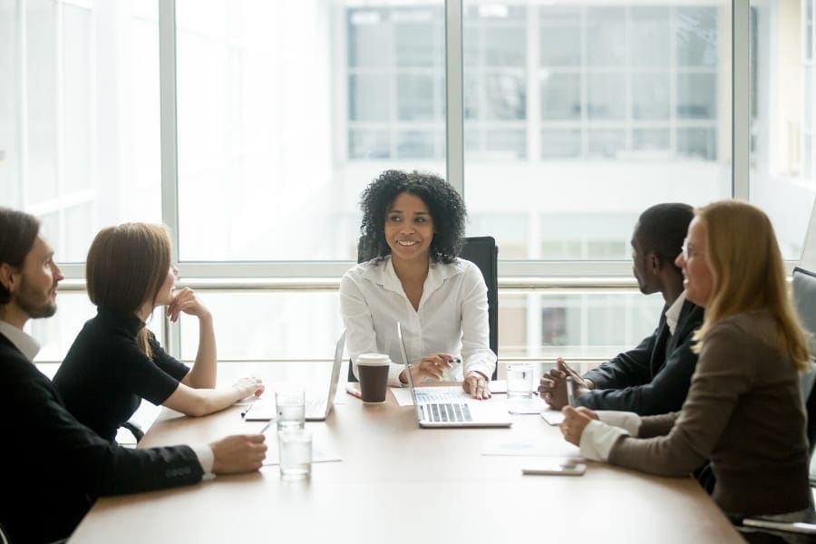 A group of career-driven business people sitting around a conference table.