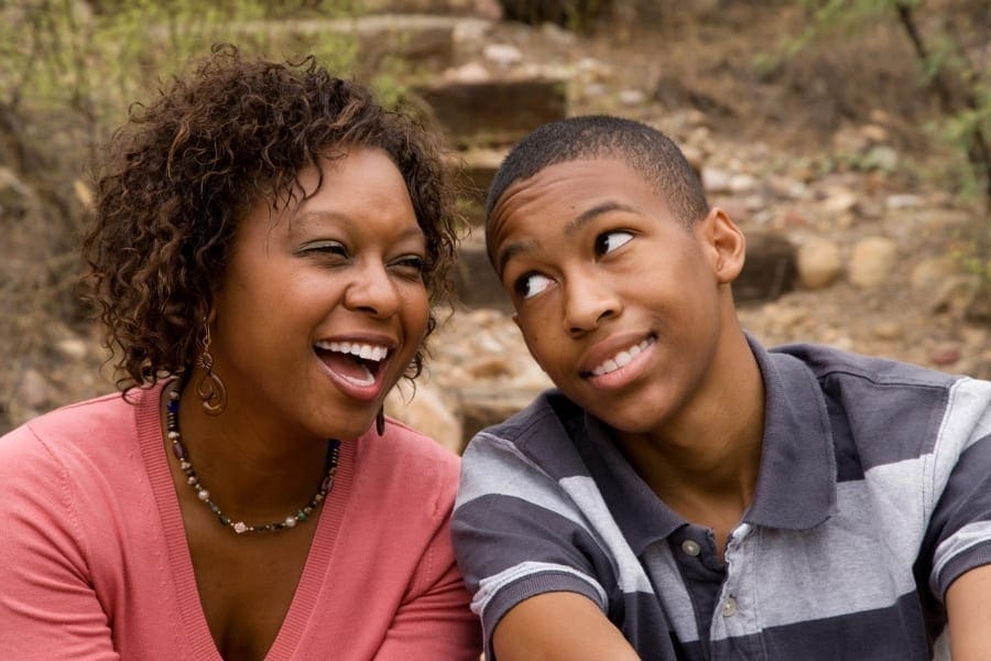 An African-American mother and her son sharing a meaningful look, reflecting on their bond and the future opportunities for career growth.