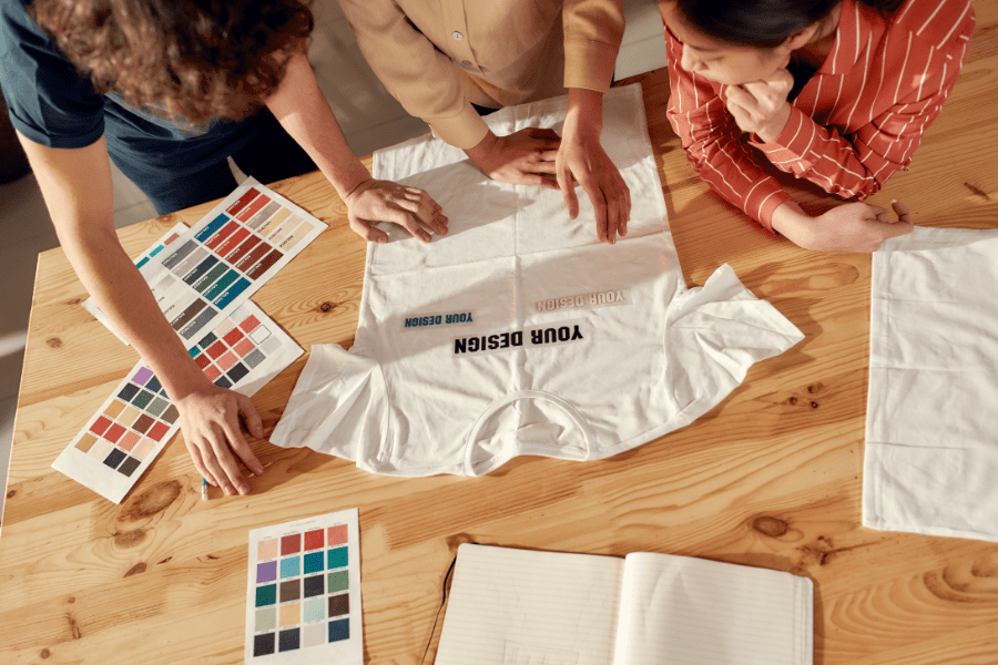 A group of people working on a t-shirt design with a focus on work-life balance.