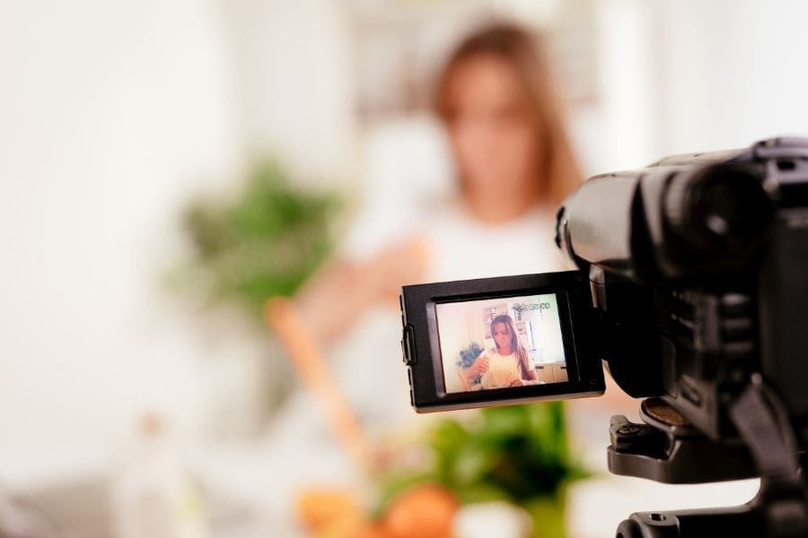 A woman is working in front of a camera, capturing a video of herself as she maintains work-life balance and navigates her career.