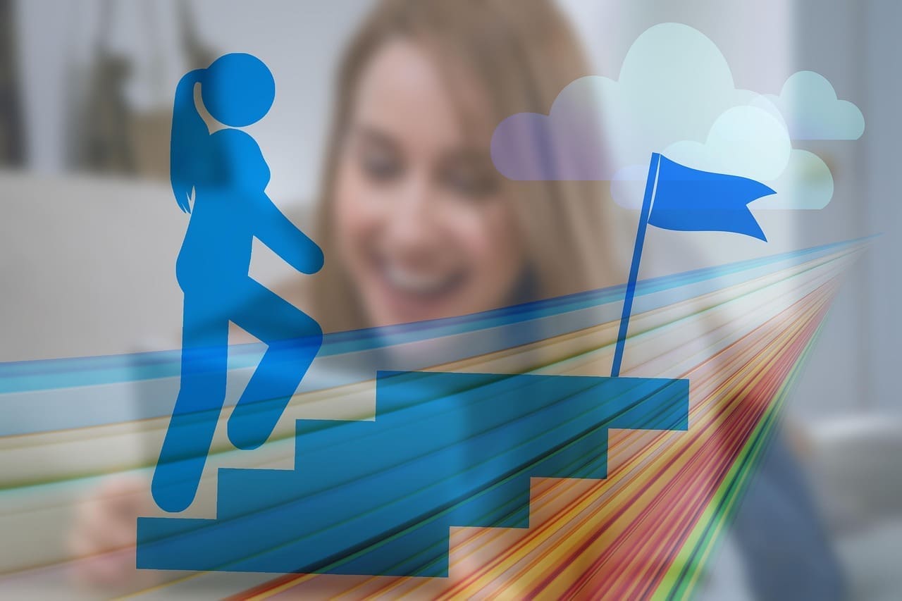 A woman smiles in the background, while in the foreground a blue graphic shows a person climbing stairs toward a flag, symbolizing progress and achievement on the journey to start a career or make a successful career change.
