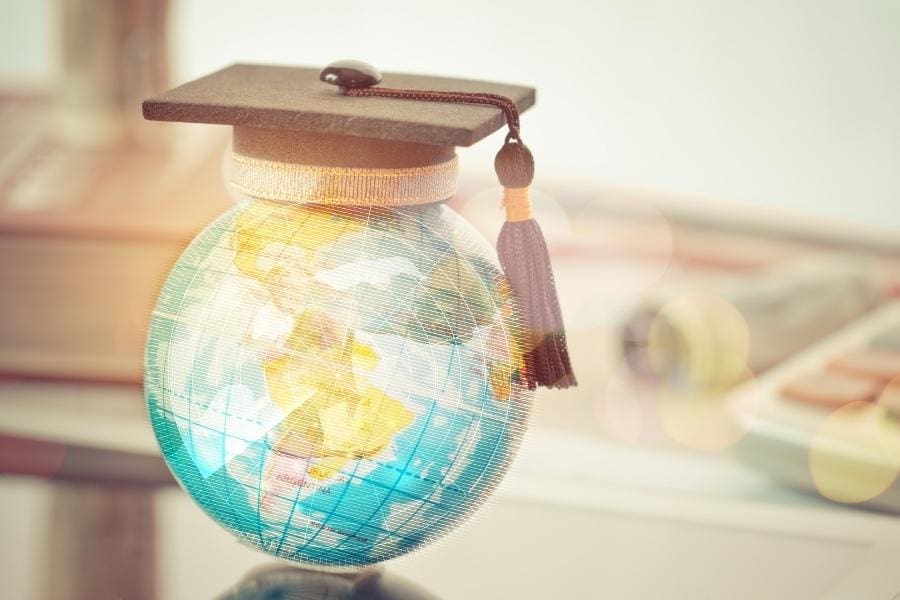 A graduation cap symbolizing post graduate success placed on a globe.