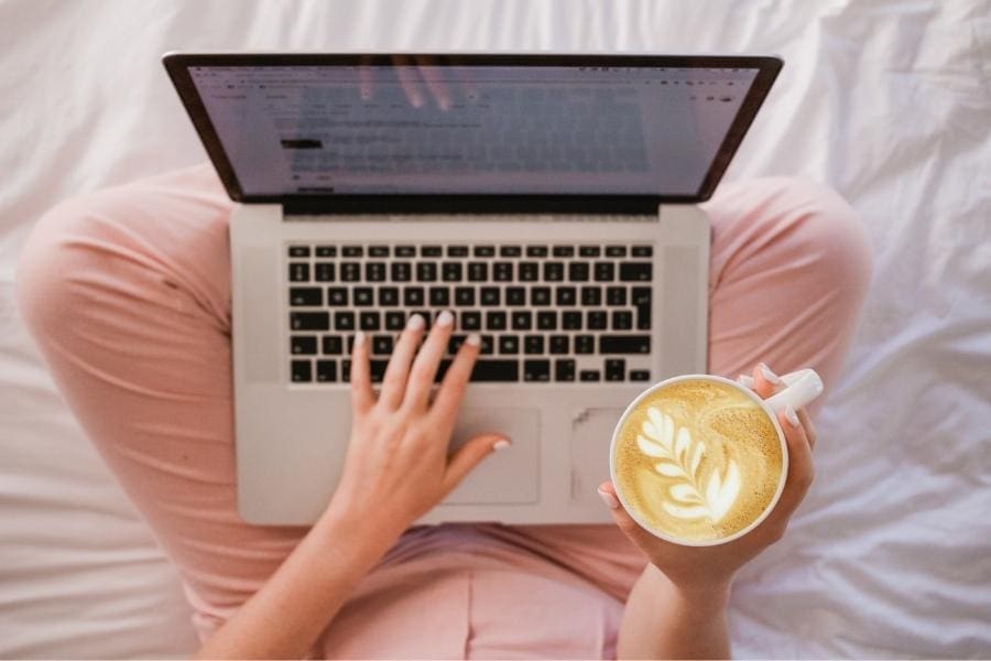 A woman using a laptop to achieve success as a blogger.