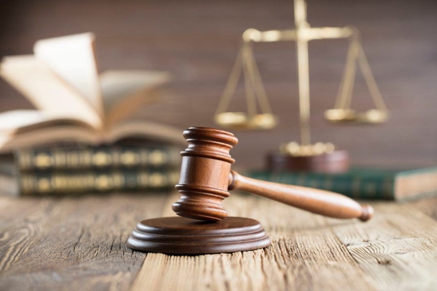 A wooden gavel balances work life and legal battles with helpful tips.