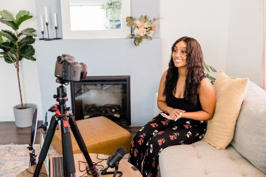 A woman creating her own video channel with a camera in front of her.