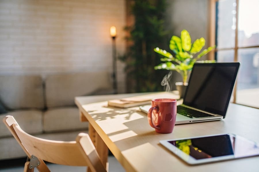 An adaptable work space with a laptop and a cup of coffee, showcasing the future of work.